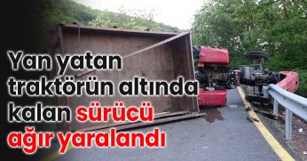 Yan yatan traktörün altında kalan sürücü ağır yaralandı