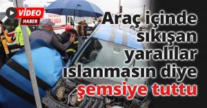 Araç içinde sıkışan yaralılar ıslanmasın diye şemsiye tuttu