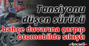Tansiyonu düşen sürücü bahçe duvarına çarpıp otomobilde sıkıştı
