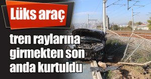 Lüks araç, tren raylarına girmekten son anda kurtuldu