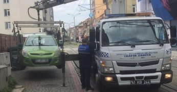 Tramvay yoluna park edilen araçlar çekiliyor