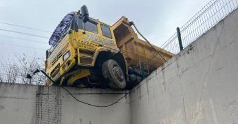 Hafriyat kamyonu istinat duvarında askıda kaldı