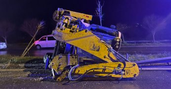 Bariyere çarpan iş makinesi refüje devrildi: 2 yaralı