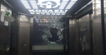 Kaldırım taşları ile asansörün camını parçaladı